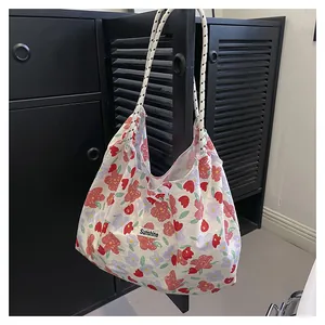 Detailed macro view of the floral canvas tote bag featuring black and white rope handles