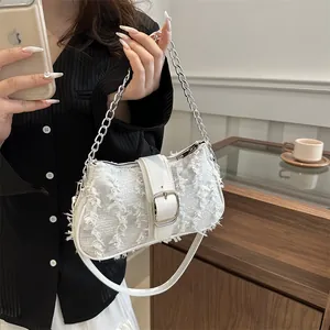 White tweed handbag with fringe texture, silver buckle, and chain strap in cafe setting