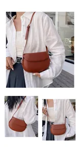 Détail d'un sac besace marron rouge vintage en cuir mat avec fermeture à rabat