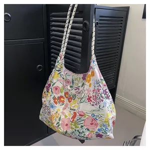 Detailed shot of floral canvas tote bag featuring braided rope handles and Sunshine label