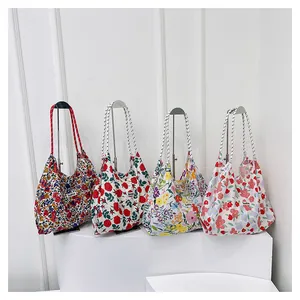 Detail of four floral canvas tote bags with various flower patterns and rope handles