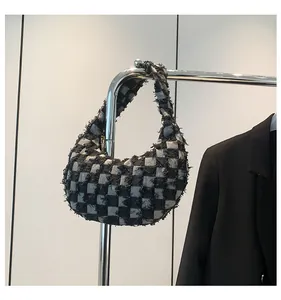 Detail of checkered canvas bag featuring trendy fringe edges and black white pattern