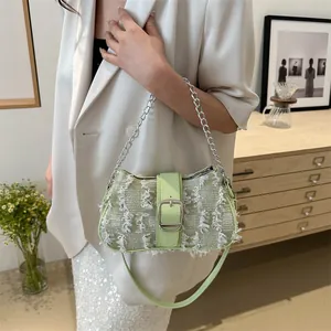 Detail of light green tweed texture shoulder bag with fringe trim and metal chain strap