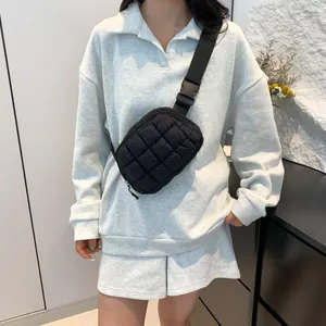 Détail d'un sac banane noir matelassé avec bandoulière réglable porté en sac à bandoulière