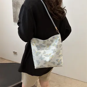 Elegant light blue underarm bag with gold butterfly embroidery and slender strap