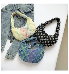 Detailed macro view of denim crescent armpit bags with fringe edges and plaid star patterns