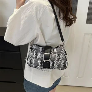 Model view of black and white tweed crossbody bag with silver buckle and chain detail