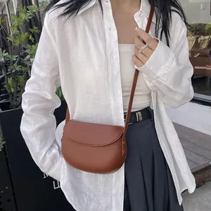 Sac besace marron chic au design minimaliste avec rabat et fine bandoulière en cuir