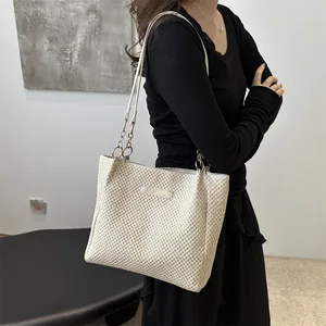 Bolso de hombro grande de paja tejida beige con cadena dorada y detalle de etiqueta