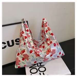 Detailed view of floral canvas tote bag with artistic red and blue flower patterns