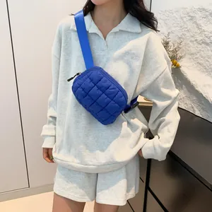 Sac banane matelassé bleu porté par un mannequin dans un cadre lifestyle décontracté