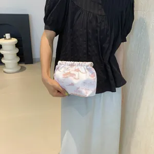 Détail d'une pochette plissée blanche avec motif de paysage chinois rose