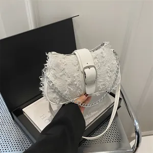 Detailed view of white tweed shoulder bag with silver chain and leather buckle strap