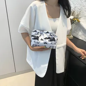 Détail de la pochette nuage blanche avec peinture à l'encre noire et texture plissée
