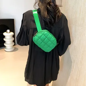 Vue détaillée du sac banane matelassé vert émeraude porté en bandoulière par l'arrière
