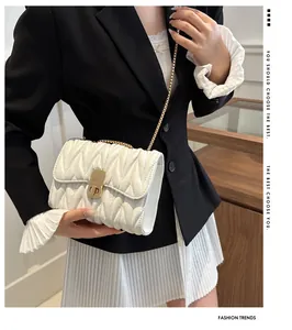Détail du sac bandoulière blanc matelassé avec chaîne dorée et fermoir en métal élégant