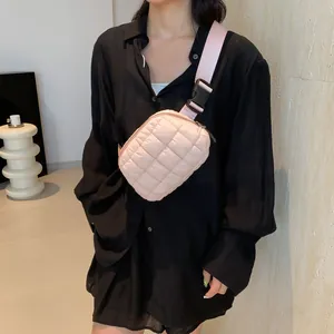 Détail du sac bandoulière matelassé rose avec large sangle et boucle sur modèle