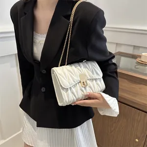 Détail du petit sac blanc matelassé avec bandoulière chaîne dorée et fermoir rotatif
