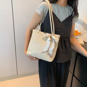 Beige woven straw tote bag with heart pattern bow accessory for women's commute