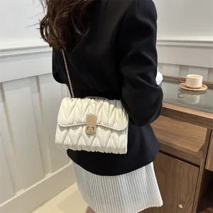 Vue détaillée du sac à chaîne matelassé blanc avec fermoir doré et texture matelassée douce