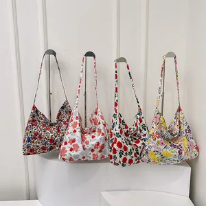 Floral print canvas tote bags in four patterns displayed on minimalist metal stands
