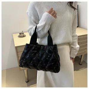 Détail du sac cabas matelassé noir avec motif en losanges et poignées en sangle