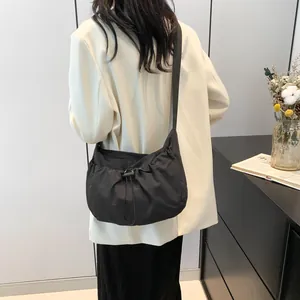 Detailed close-up of black cloud-shaped shoulder bag with drawstring closure and wide strap