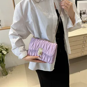 Détail du sac lilas matelassé avec fermoir rotatif doré et bandoulière chaîne