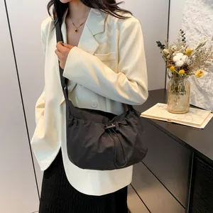 Minimalist black drawstring crossbody bag styled with professional urban commuter outfit