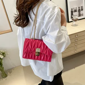 Détail du sac bandoulière en cuir matelassé fuchsia avec chaîne dorée et fermoir