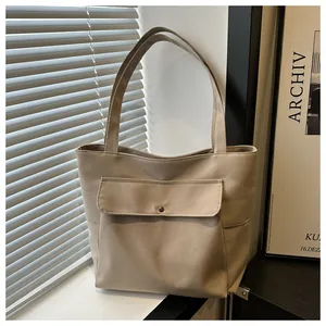 Détail du sac fourre-tout en toile montrant la poche à rabat avec bouton pression