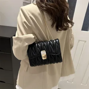 Détail du sac bandoulière matelassé noir avec fermoir doré et bandoulière chaîne