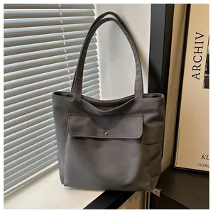 Vue détaillée du cabas en toile gris foncé avec poche avant à bouton-pression en métal