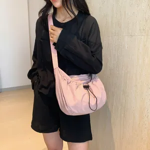Pink nylon crossbody bag with drawstring design and adjustable strap for casual daily use