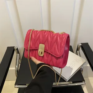 Détails du sac matelassé fuchsia avec bandoulière chaîne dorée et fermoir pivotant chic