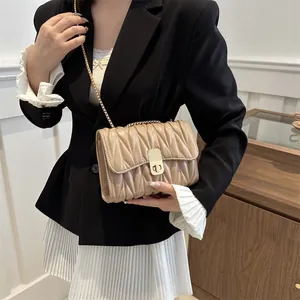 Sac bandoulière beige matelassé avec chaîne dorée et finition texturée élégante