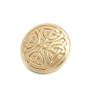 Detailed close-up of a gold round metal button featuring an embossed Celtic knot design