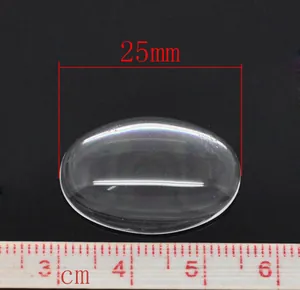 Detailed view of a 25mm oval transparent glass cabochon with metric ruler scale