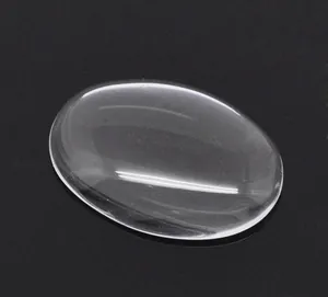 Close-up of clear oval glass cabochon for DIY jewelry making on black background