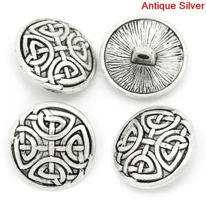 Close-up of four antique silver metal buttons with embossed Celtic knot patterns