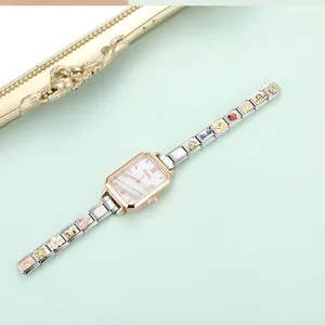 Detailansicht des Charm-Armbands mit farbenfrohen Emaille-Anhängern wie Katze und Gänseblümchen
