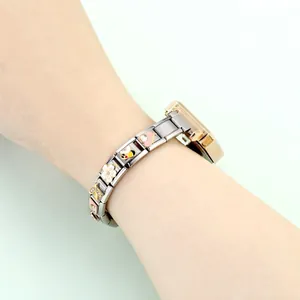 Detailansicht eines Modul-Armbands mit Emaille-Biene und Herzanhängern am Handgelenk