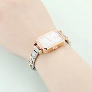 Nahaufnahme der rechteckigen roségoldenen Uhr mit dekorativem Edelstahl-Schiebearmband