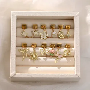 Dettaglio di ciondoli a fiore e fiocco per bracciali italiani in portagioie elegante