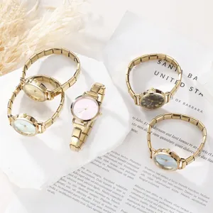 Dettaglio del set di cinque orologi dorati con cinturini modulari e quadranti colorati