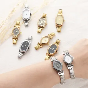Elegant gold and silver link watches with minimalist dials displayed on soft fabric