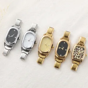 Flat lay of retro metal quartz watches with colorful dials on a textured beige fabric