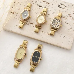Close-up of assorted gold metal link watches with diverse patterned and crystal dials