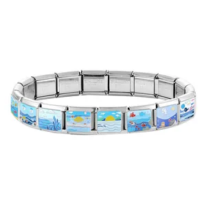 Macro detail of Italian charm bracelet with enamel ocean sunrise and sea life patterns