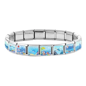 Macro detail of nautical ocean charms and stainless steel hallmark on modular bracelet